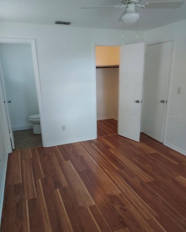 unfurnished bedroom with dark hardwood / wood-style floors, ceiling fan, and ensuite bathroom