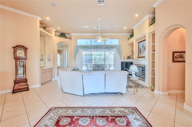 living room with crown molding, light tile patterned floors, and built in features