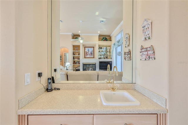 bathroom featuring vanity, crown molding, and ceiling fan