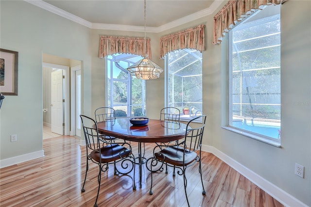 dining area featuring ornamental molding and light wood-type flooring