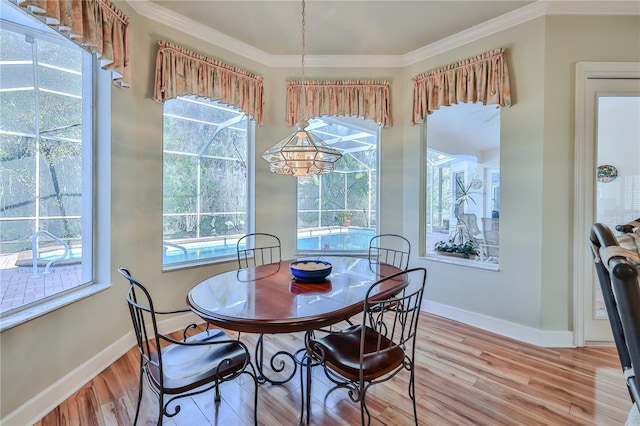 dining space featuring crown molding, plenty of natural light, and hardwood / wood-style floors