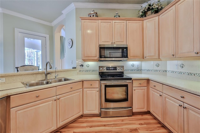 kitchen featuring light brown cabinetry, sink, crown molding, light wood-type flooring, and stainless steel appliances