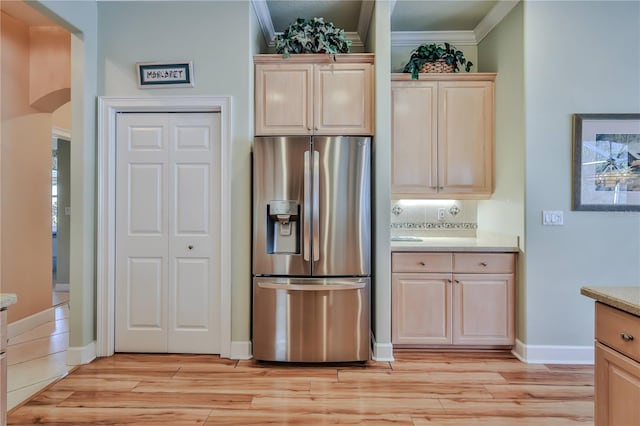 kitchen featuring ornamental molding, light hardwood / wood-style floors, light brown cabinetry, and stainless steel fridge with ice dispenser