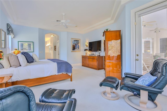 bedroom with connected bathroom, light colored carpet, and ceiling fan