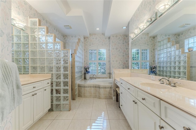 bathroom featuring a relaxing tiled tub, vanity, tile patterned flooring, and a wealth of natural light