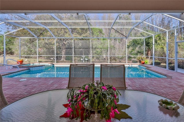 view of swimming pool with a patio area, an in ground hot tub, and glass enclosure