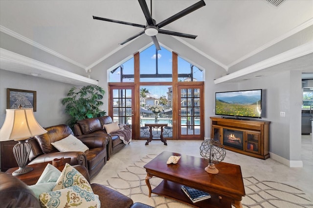 living room with lofted ceiling, light colored carpet, ornamental molding, and ceiling fan