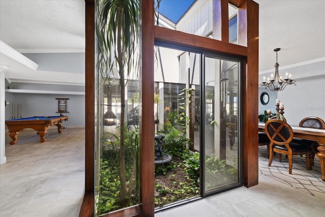 doorway to outside with pool table, ornamental molding, and a chandelier