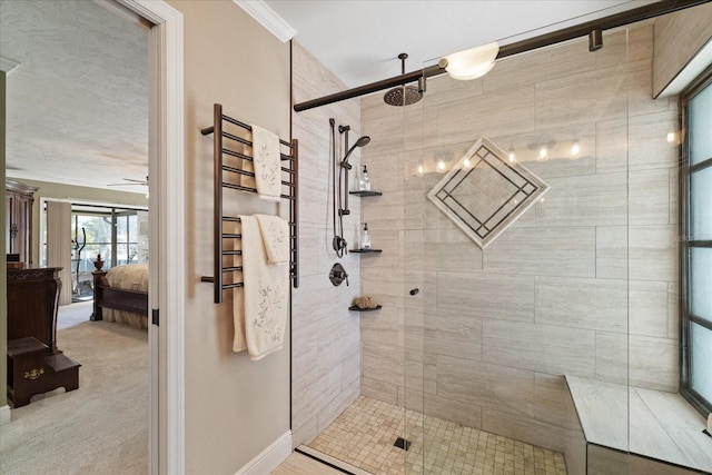 bathroom featuring ceiling fan, ornamental molding, and a shower with door