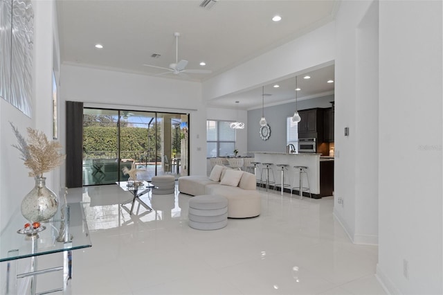 living room with ornamental molding and ceiling fan