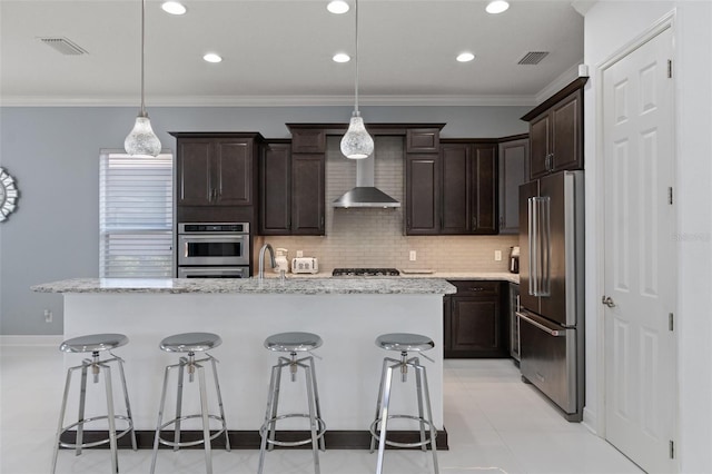 kitchen featuring a center island with sink, pendant lighting, a breakfast bar area, and high end refrigerator