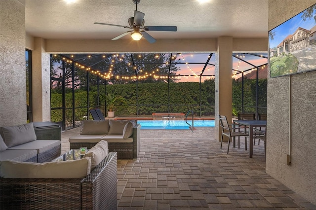 patio terrace at dusk featuring an outdoor living space, a lanai, and ceiling fan