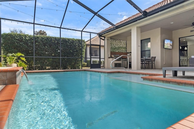 view of pool with pool water feature, ceiling fan, a lanai, and a patio