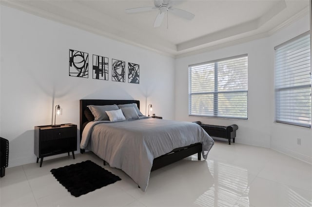 bedroom with light tile patterned flooring, ornamental molding, ceiling fan, and a tray ceiling