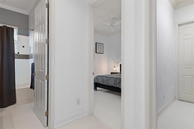 corridor with crown molding and light tile patterned floors