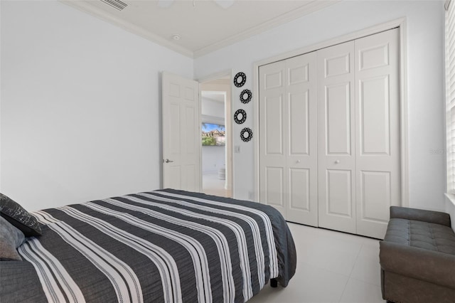 bedroom featuring crown molding, light tile patterned floors, ceiling fan, and a closet