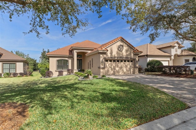 mediterranean / spanish home with a garage and a front yard