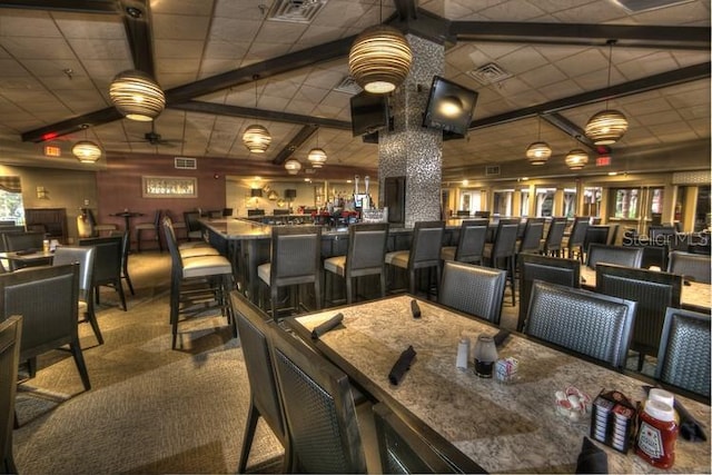 interior space featuring ceiling fan, carpet floors, and a drop ceiling