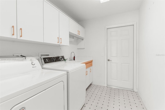 washroom with cabinets, sink, and washing machine and clothes dryer