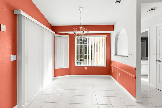 unfurnished dining area featuring light tile patterned floors and an inviting chandelier