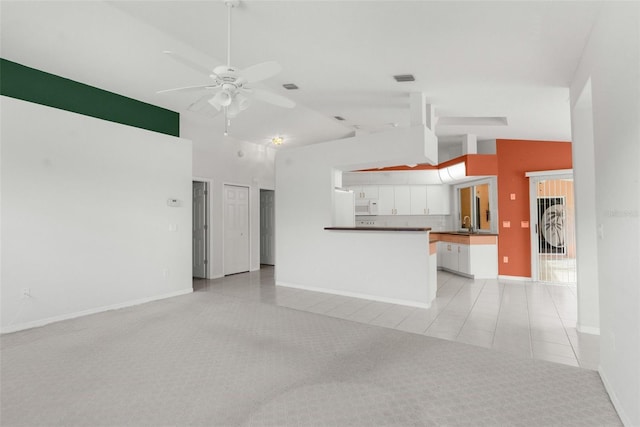 unfurnished living room featuring high vaulted ceiling, light colored carpet, and ceiling fan