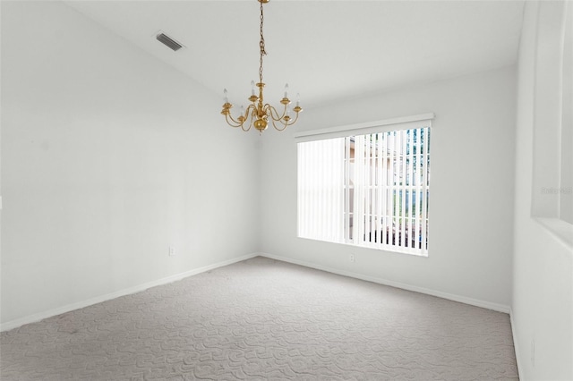 carpeted spare room featuring a notable chandelier