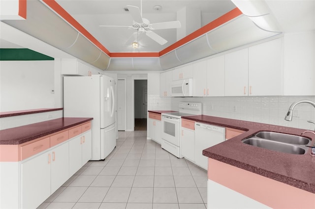 kitchen featuring sink, white appliances, white cabinetry, tasteful backsplash, and a tray ceiling