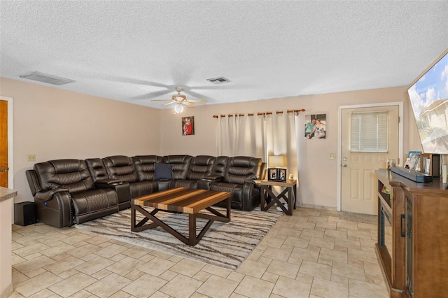 living room with a textured ceiling and ceiling fan