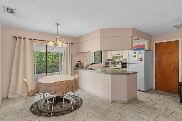 kitchen with pendant lighting, white cabinetry, backsplash, a notable chandelier, and white fridge