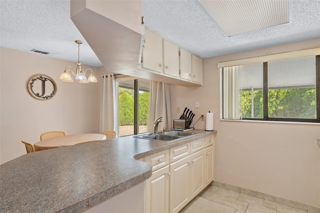 kitchen with sink, pendant lighting, and a textured ceiling