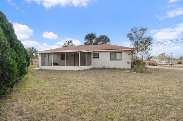 back of property featuring a yard and a sunroom