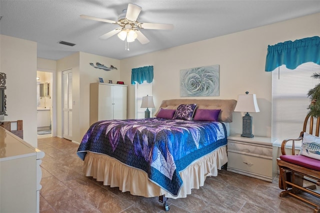 bedroom with ensuite bathroom, a textured ceiling, ceiling fan, and a closet