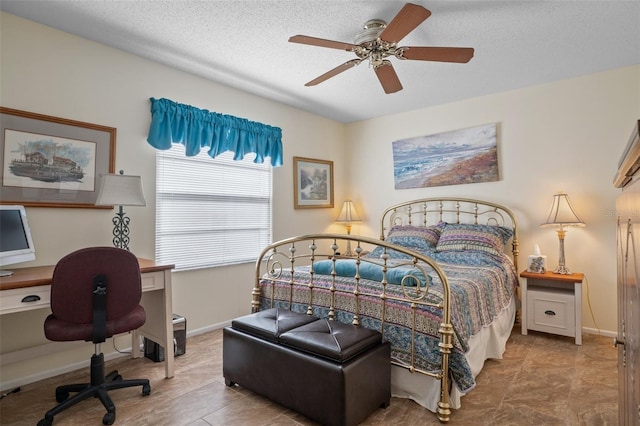 bedroom with ceiling fan and a textured ceiling