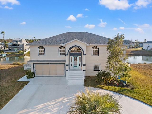 view of front facade featuring a water view, a garage, and a front yard