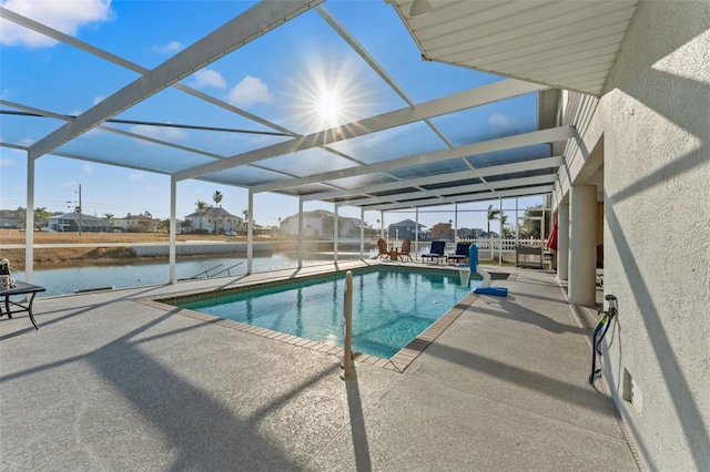 view of swimming pool featuring a water view, a patio area, and glass enclosure