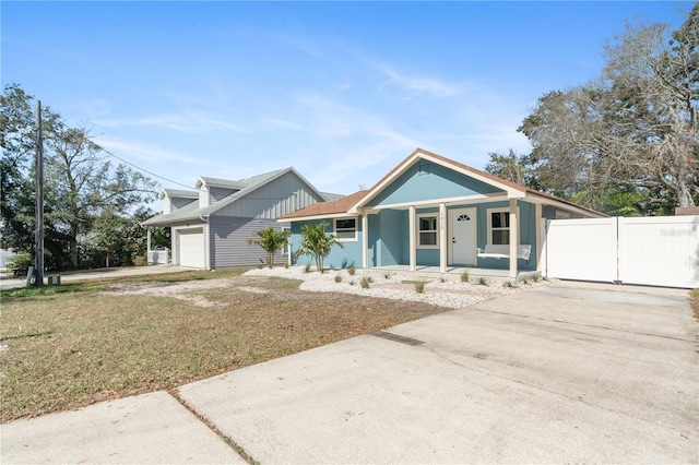 view of front of house with a garage, a front yard, and covered porch