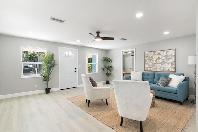 living room featuring ceiling fan, a healthy amount of sunlight, and light hardwood / wood-style flooring