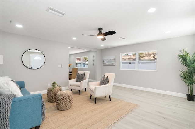 living area with ceiling fan and light hardwood / wood-style flooring