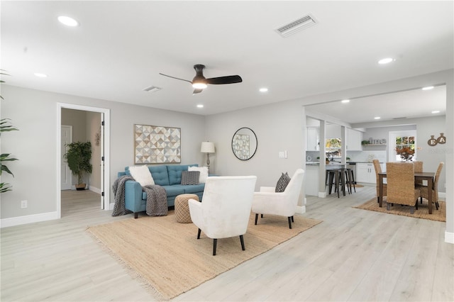 living room featuring ceiling fan and light hardwood / wood-style flooring