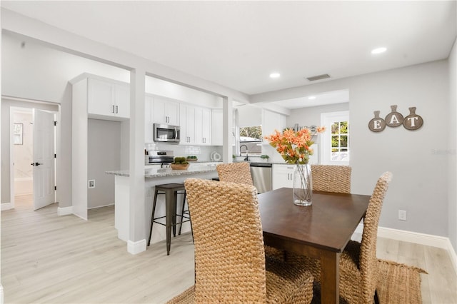 dining room featuring sink and light wood-type flooring