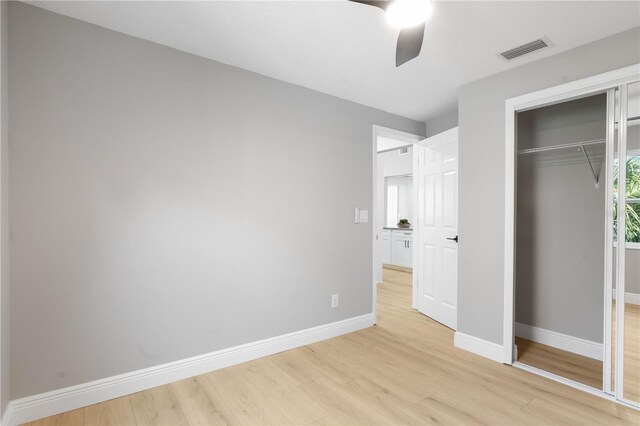 unfurnished bedroom featuring ceiling fan, light hardwood / wood-style floors, and a closet