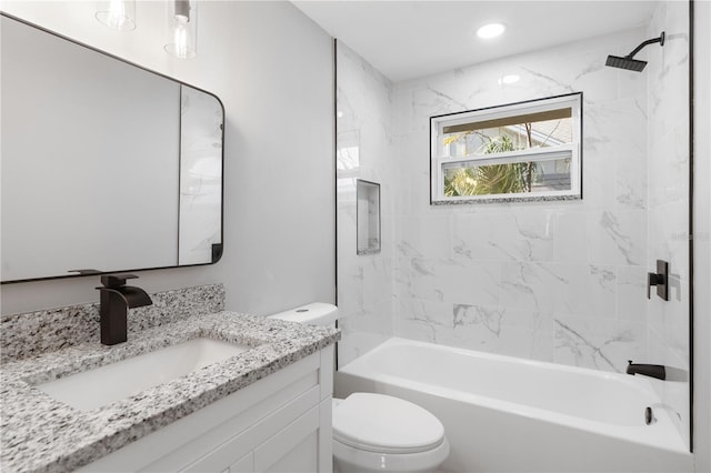 full bathroom featuring tiled shower / bath, vanity, and toilet