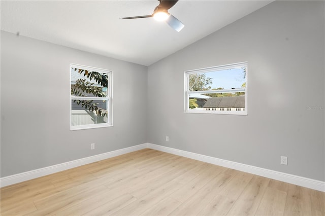 empty room with ceiling fan, lofted ceiling, and light hardwood / wood-style flooring