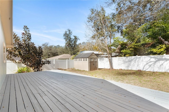 wooden deck with a shed and a lawn