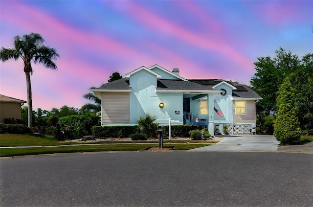 5771 Catskill Rd, Holiday, FL 34690 - view of front of house with a chimney, a porch, and concrete driveway