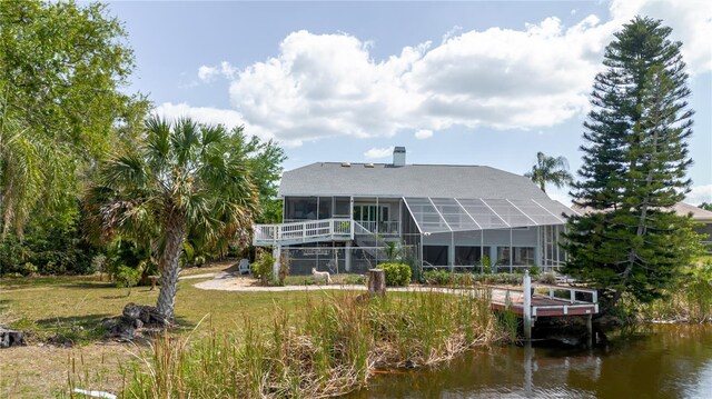 5771 Catskill Rd, Holiday, FL 34690 - back of house with a water view, a sunroom, and a chimney