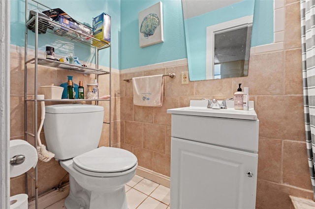 bathroom featuring toilet, tile patterned floors, curtained shower, vanity, and tile walls