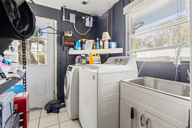 washroom featuring cabinet space, plenty of natural light, light tile patterned floors, and washer and dryer