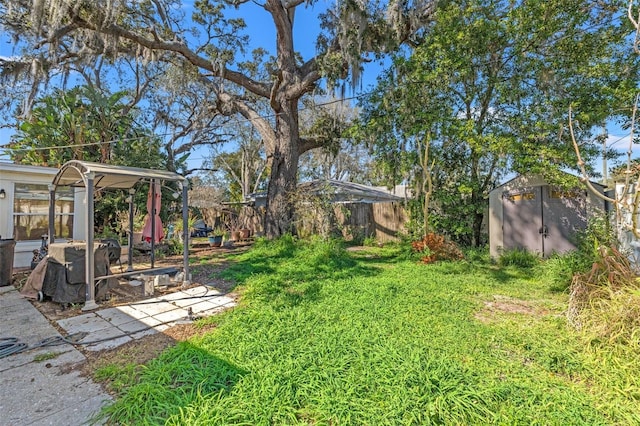 view of yard with fence, an outdoor structure, and a shed