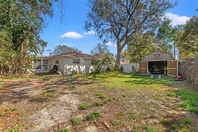 view of yard featuring a sunroom, fence, and an outdoor structure